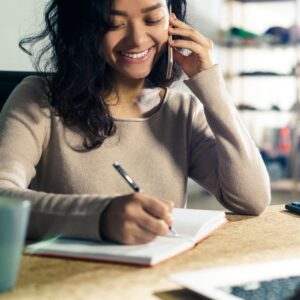 Person talking on the phone and taking notes