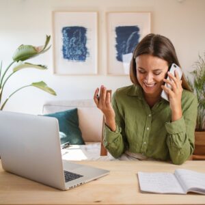 Person talking on the phone and using a laptop while working from home