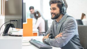 Person smiling while wearing a headset in an office setting